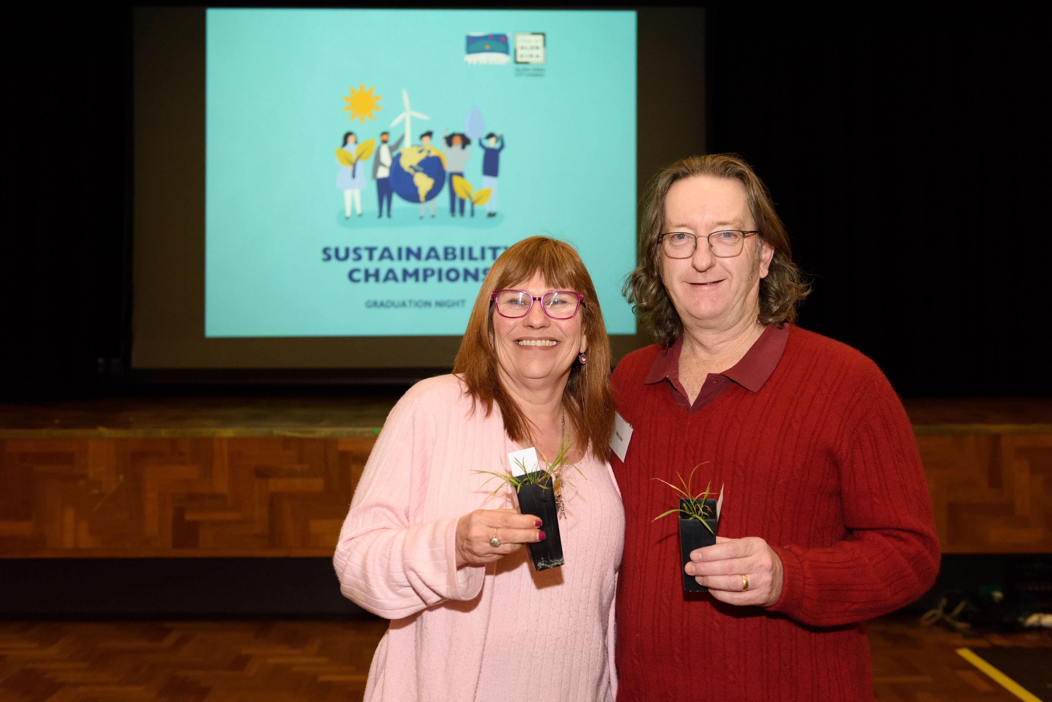 Two people holding plants at the Sustainability Champions graduation