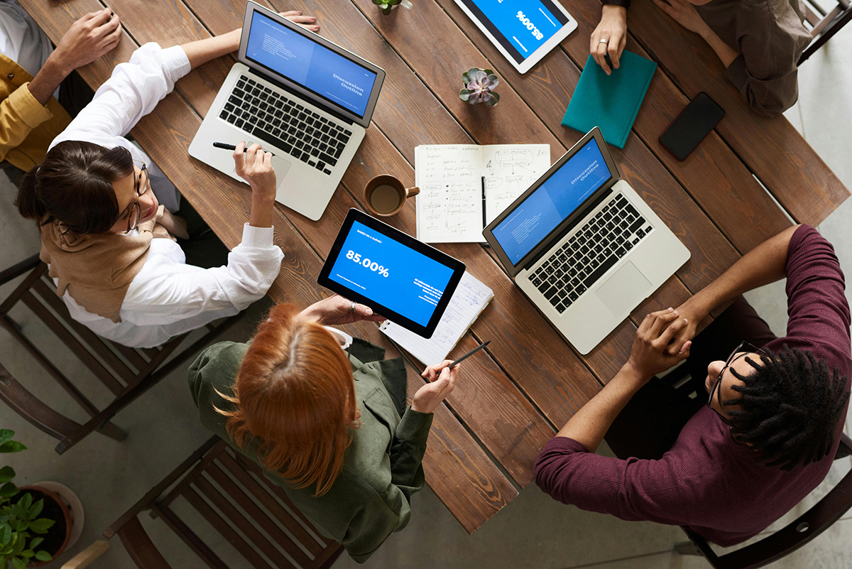 people with laptops sitting around a table