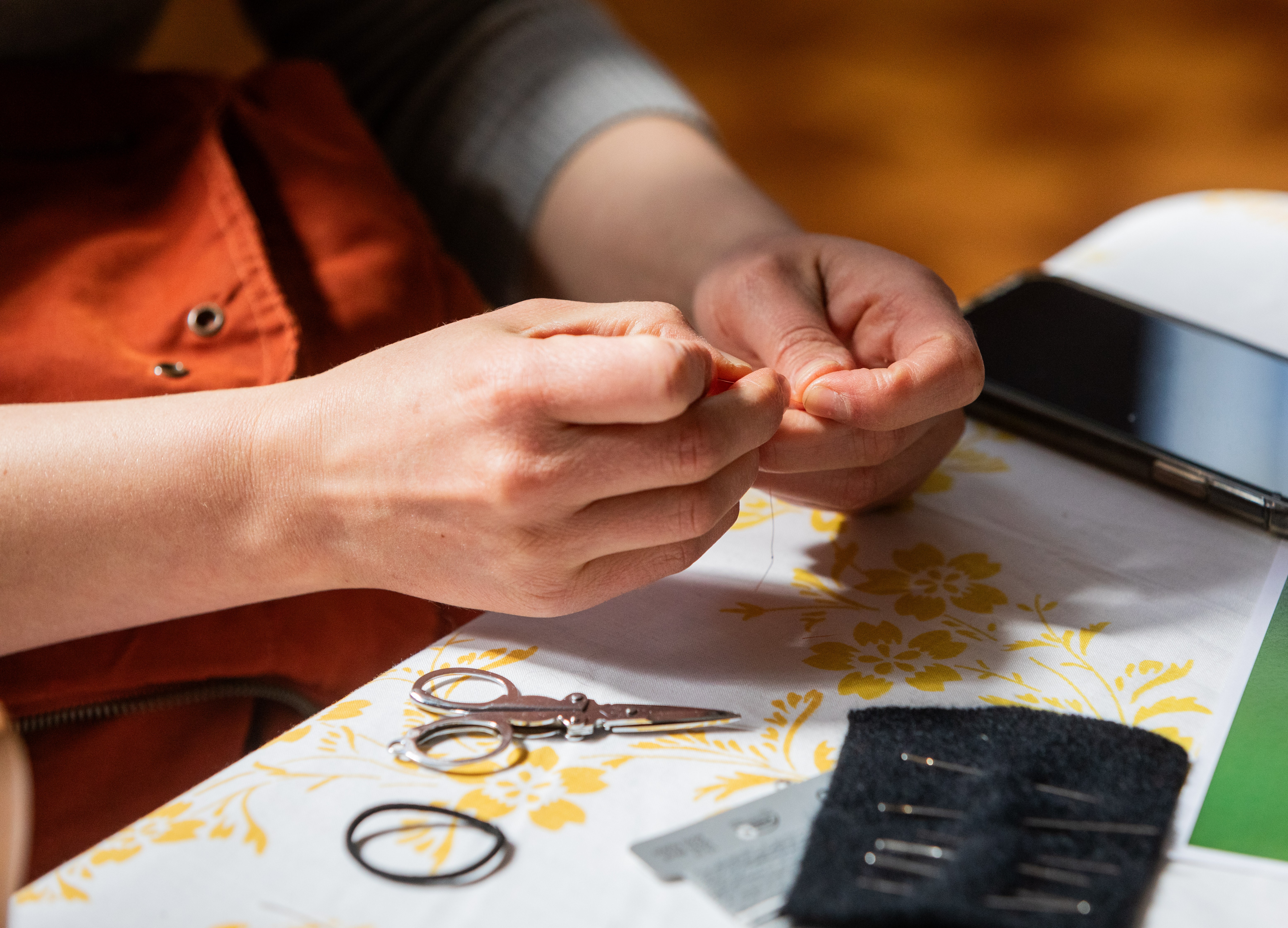 Close up of a person mending with a needle and thread